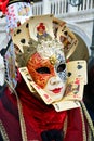 An unknown woman with two-colored mask with face and court cards